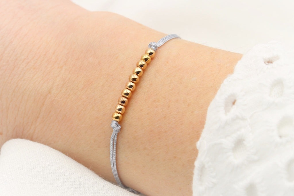 hell graues Armband mit 10 Perlen in rosegold am Handgelenk getragen