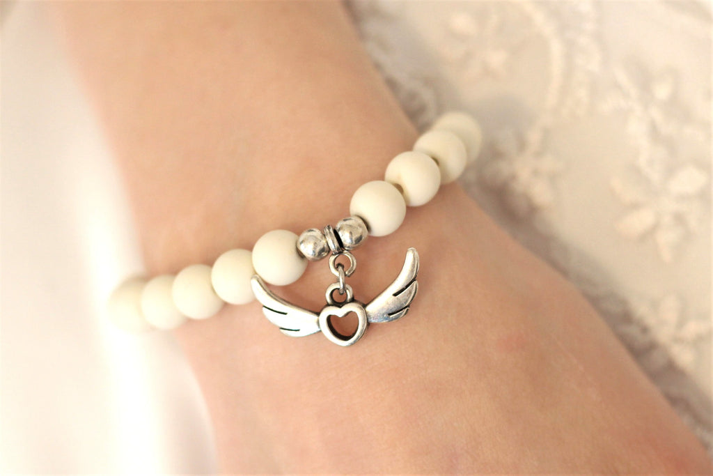 Perlenarmband Engelsflügel Anhänger in silberfarben und matten Perlen in Creme, perfekt für Kommunion und Konfirmation