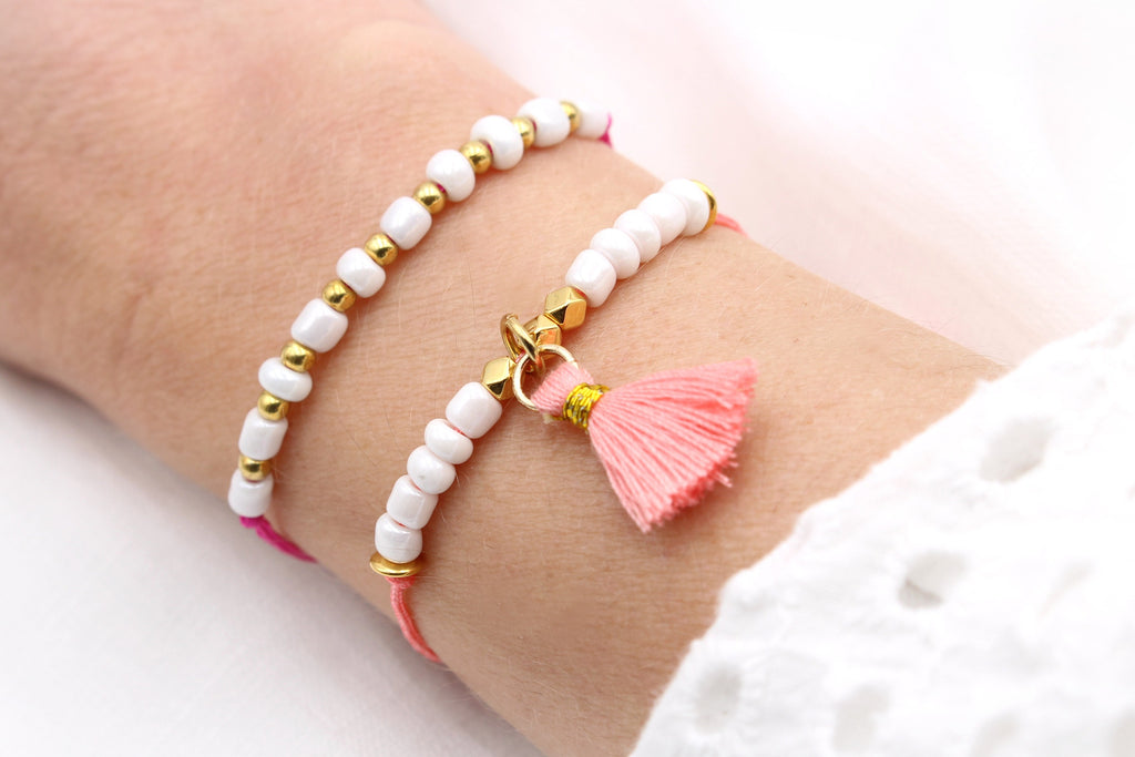 2er Set Sommer Armband Damen Pink Orange Gold am Handgelenk der Frau getragen mit zarter Quaste als Anhänger