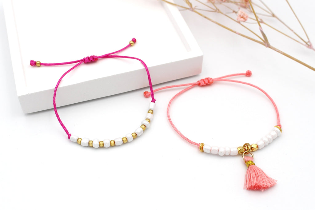 2 Sommer Armbänder im Ibiza Style in pink und Koralle mit zarten weißen und goldenen Details sowie einer kleinen Quaste als Anhänger