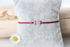 rotes Anker Armband für Frauen in silberfarben auf einem grauen Kissen befestigt