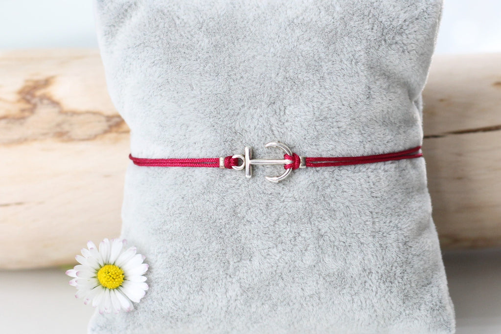 rotes Anker Armband für Frauen in silberfarben auf einem grauen Kissen befestigt