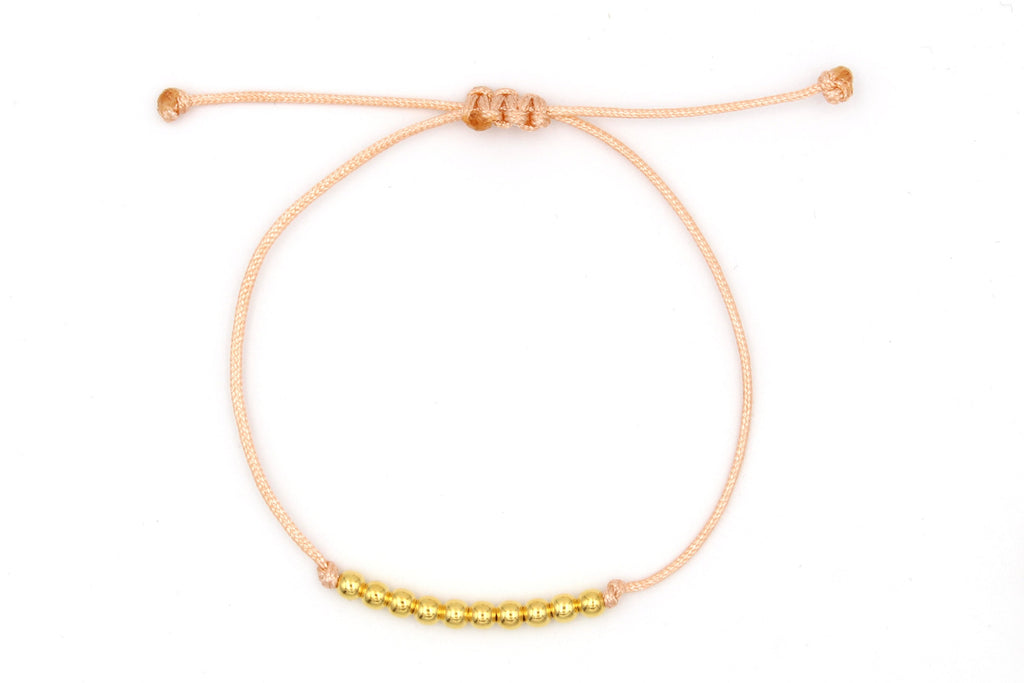 Armband aus pfirisch farbenem Makramee und 10 goldenen Perlen aus 925 Silber auf weißem Hintergrund