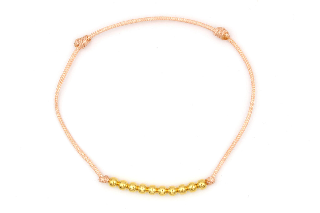 Schiebeknoten Armband mit 10 goldenen Perlen aus 925 Silber auf weißem Hintergrund