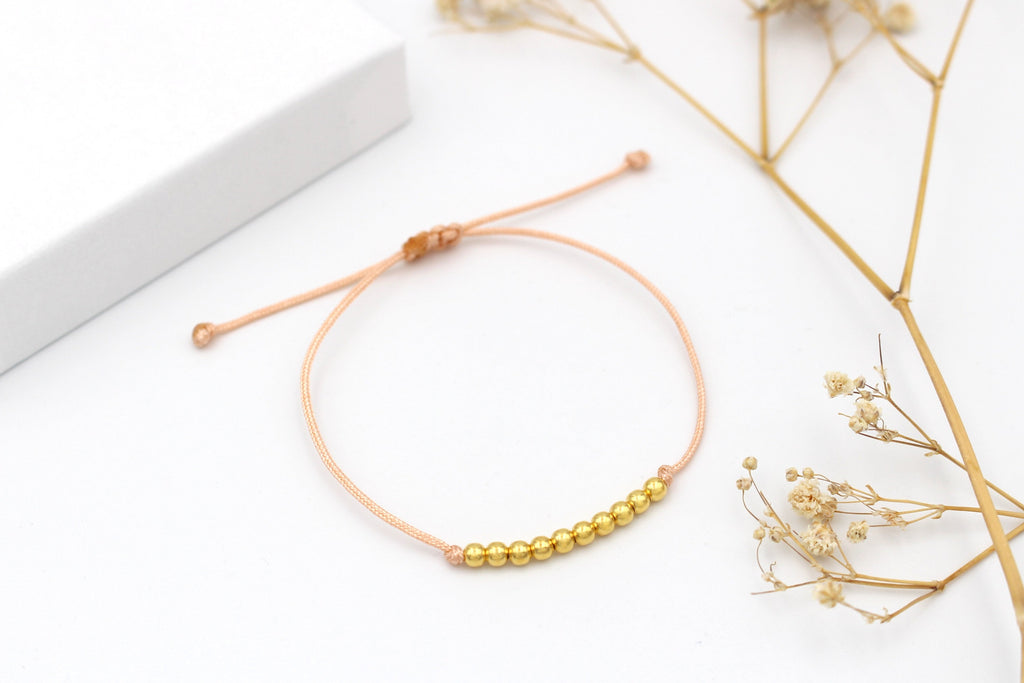Armband 10 Perlen gold auf pfirsichfarbenem Makramee Band