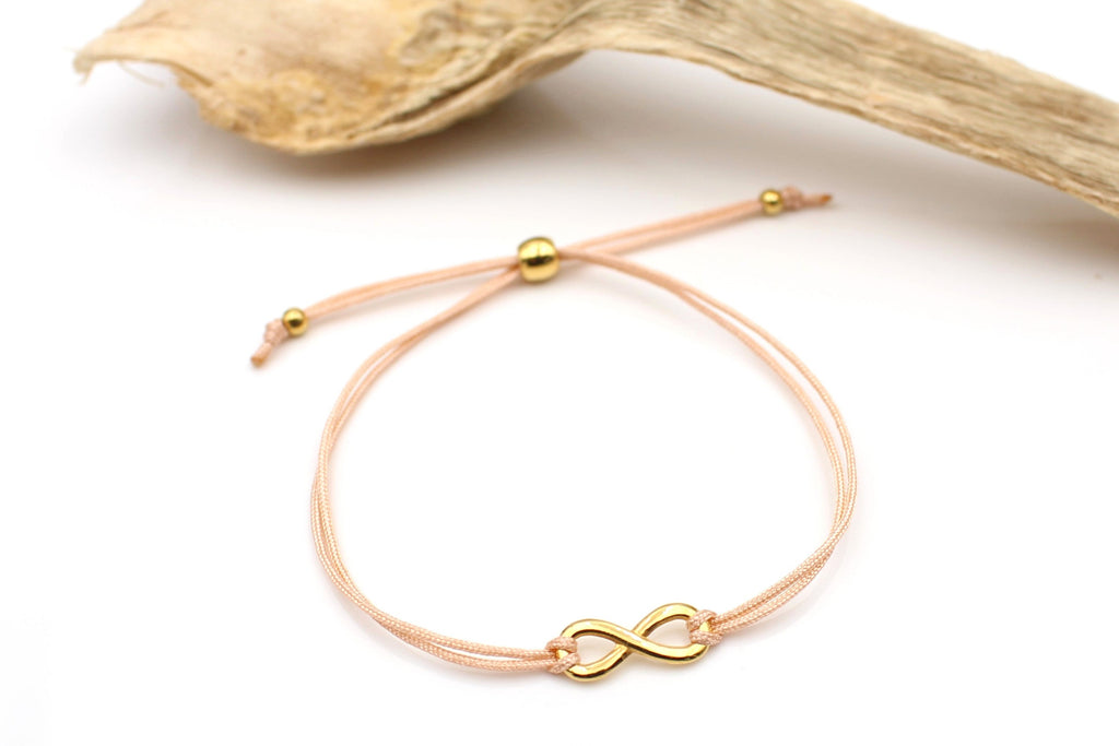 Infinity Armband in pfirsich mit Unendlichkeits Symbol und kugelförmigen Makramee Verschluss in gold