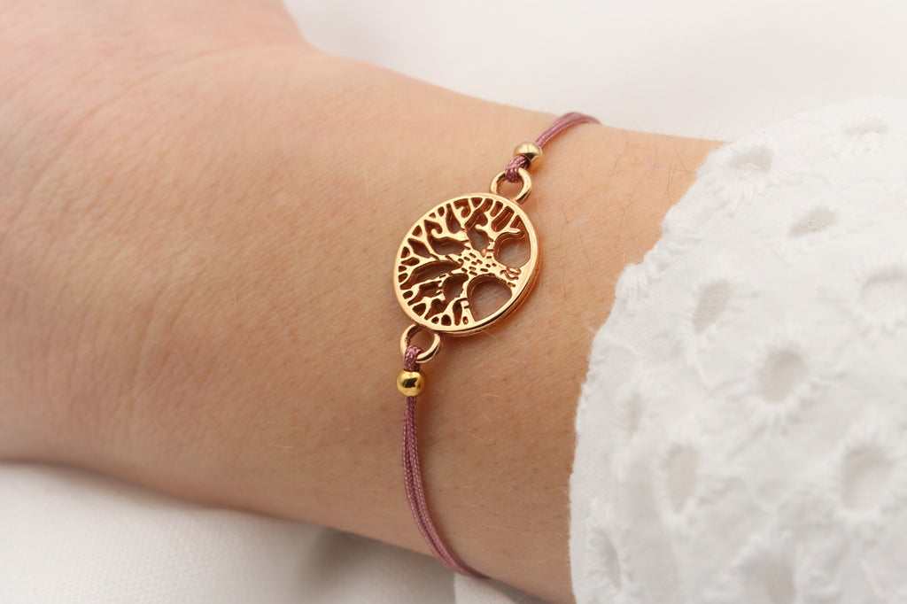 Armband Lebensbaum in rosegold und aubergine Red farbenem Makramee Band am Handgelenk der Dame getragen