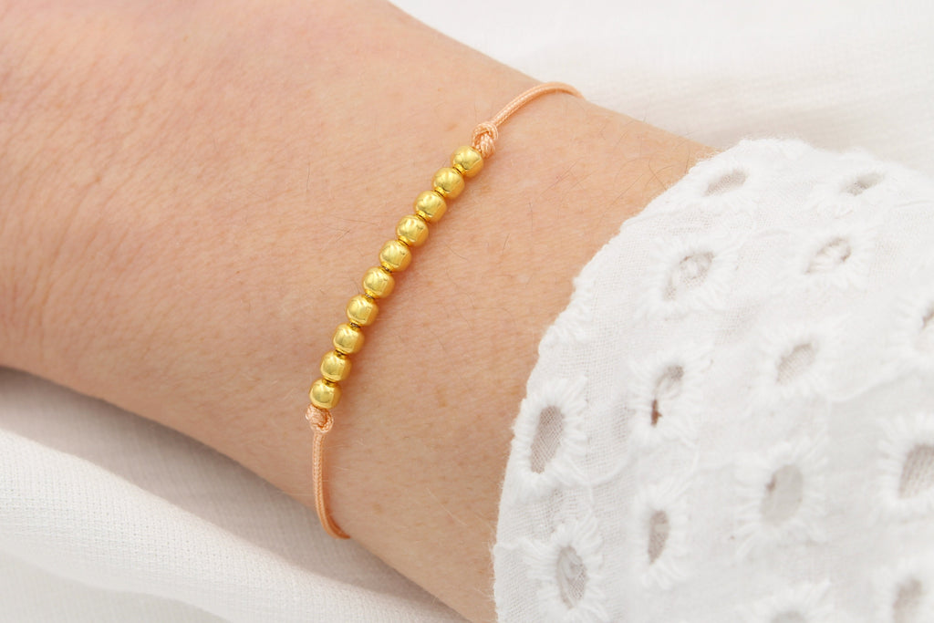 Makramee Armband mit 925 Silber Perlen vergoldet am Handgelenk der Dame getragen
