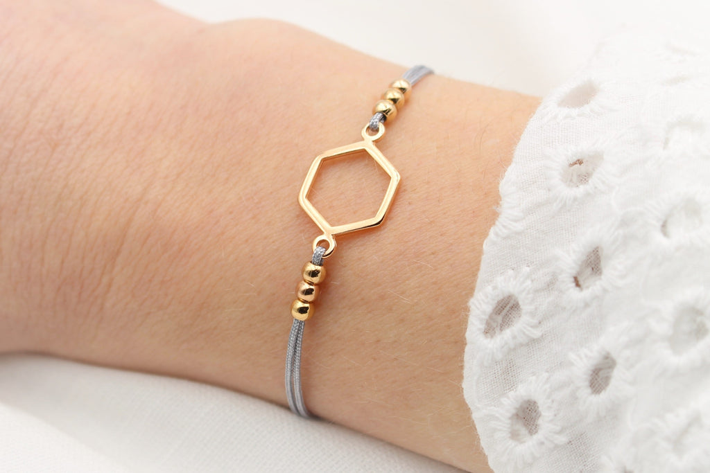 Hell graues Makramee Armband Hexagon in rosegold mit 6 kleinen Perlen am Handgelenk getragen