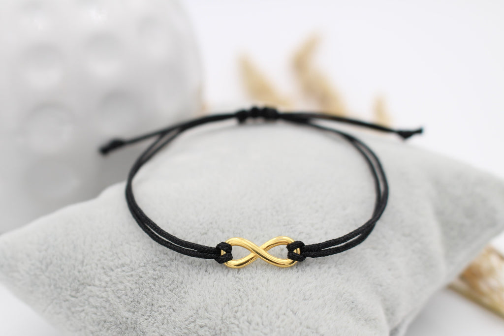 goldenes Infinity Armband mit schwarzem Makramee Band als unisex Armband für Damen und Herren