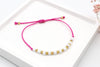 Pinkes Sommer Armband mit weißen und goldenen Perlen und geflochtenem Makramee Verschluss