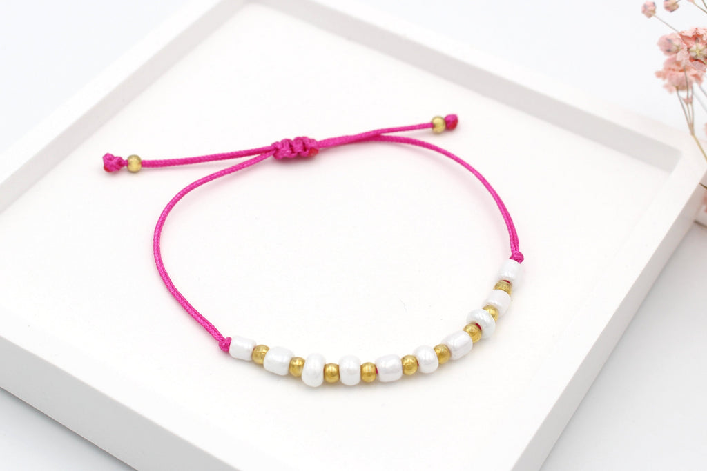 Pinkes Sommer Armband mit weißen und goldenen Perlen und geflochtenem Makramee Verschluss