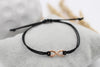 Armband der Unendlichkeit in rosegold mit schwarzem Band und geflochtenem Makramee Verschluss