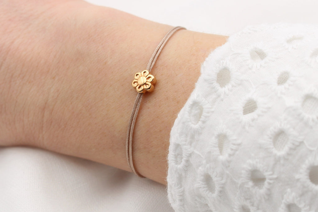 Rosenholz farbenes Makrameearmband kleine Blume rosegold am Handgelenk der Frau getragen