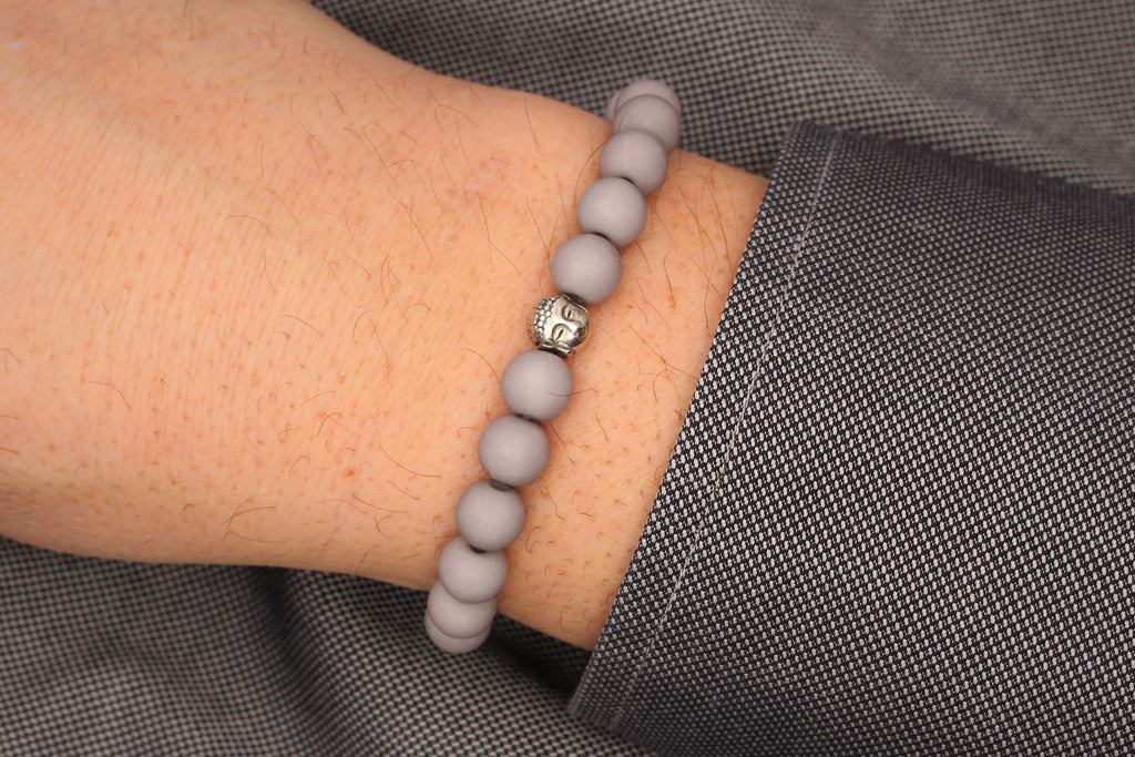 Buddha Armband Herren als Perlenarmband in hell grau am Handgelenk des Mannes getragen