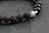 Details schwarz graues Lavaperlen Armband