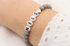 graues Perlenarmband mit Namen und Herz in silber und deinen Initialen oder Buchstaben am Handgelenk getragen