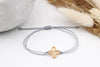 graues Makramee Armband mit goldfarbenem Kreuz und geflochtenem Verschluss