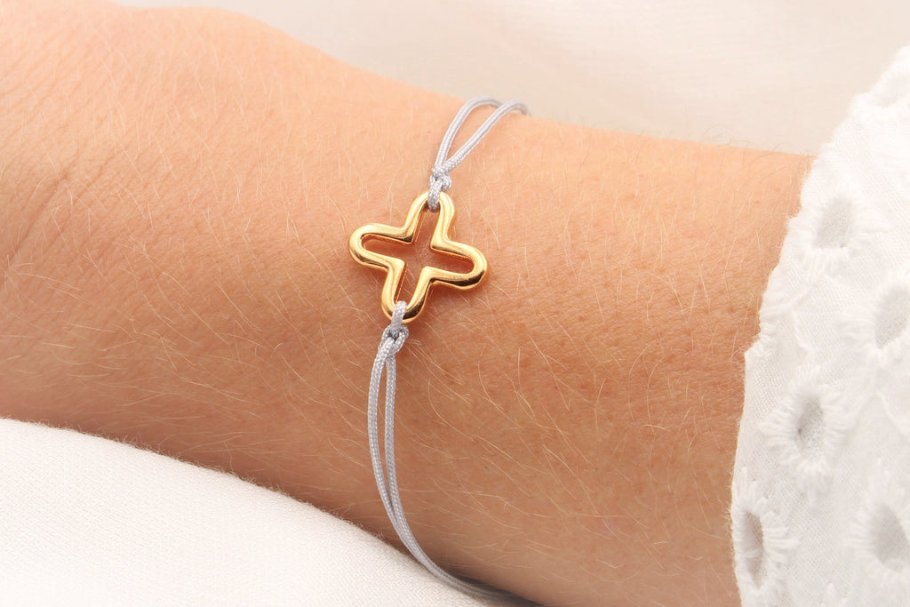 Kreuzarmband aus grauem Makramee und DQ Metall in rosegold am Handgelenk getragen