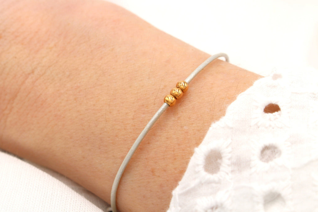 filigranes Lederarmband in ivory mit 3 Perlen rosegoldfarben am Handgelenk getragen