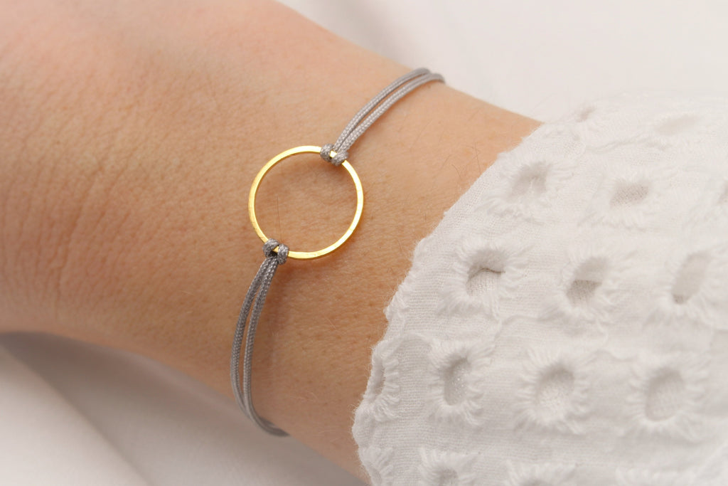 Armband Damen Kreis goldfarben und Makrameeband am Handgelenk getragen