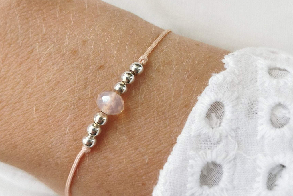 Makramee Armband in pfirsich mit 6 kleinen Perlen aus 925 Silber am Handgelenk der Dame getragen